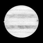 Jupiter 27. 8. 1997 ve 21 h 38 min UT, refraktor AS 110/1650, zv. 165x, výška nad obzorem 22,5°. Vlevo měsíc Io zacházející za  Jupiter, vpravo stín měsíce Europa. Jih nahoře, západ vlevo. Kresba Vladimír Kocour.)