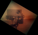 Snímek z kamery MAHLI  zachycuje kolegyně - kamery MastCam a ChemCam. Pokud vám snímek připadá trochu podivně kontrastní, tak je to proto, že byl pořízen skrze clonu, která kameru chrání před prachem. Credit: NASA